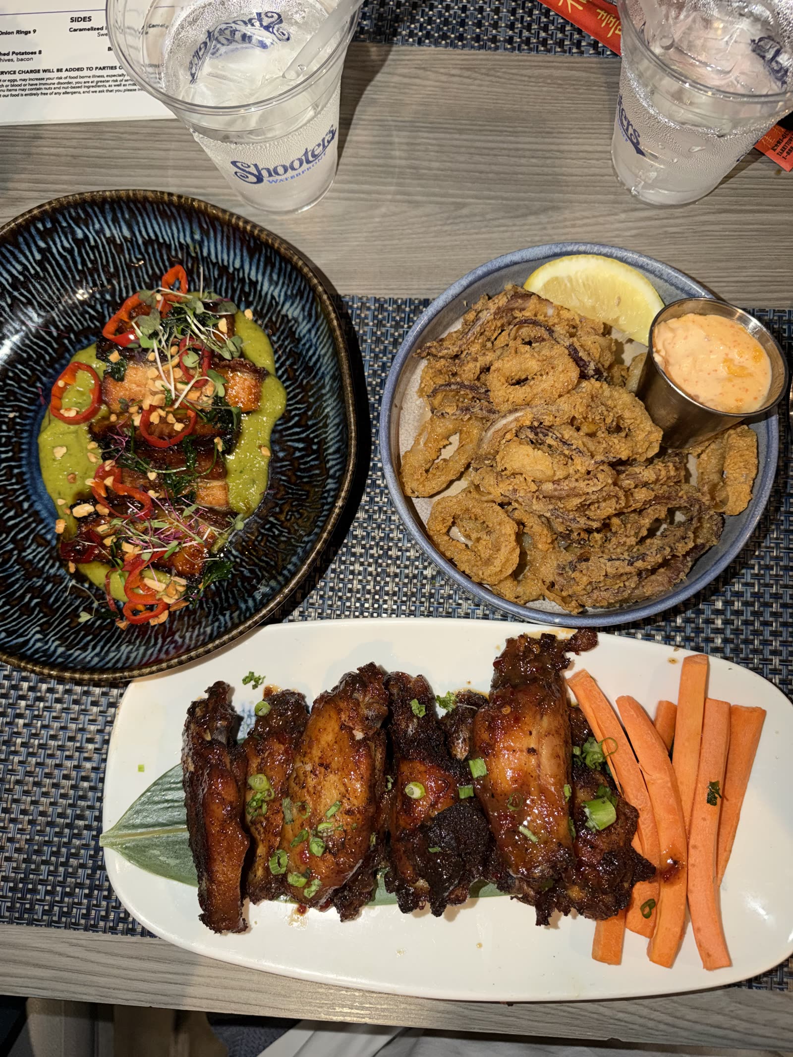 Wings, calamari and a shared appetizer spread on a table