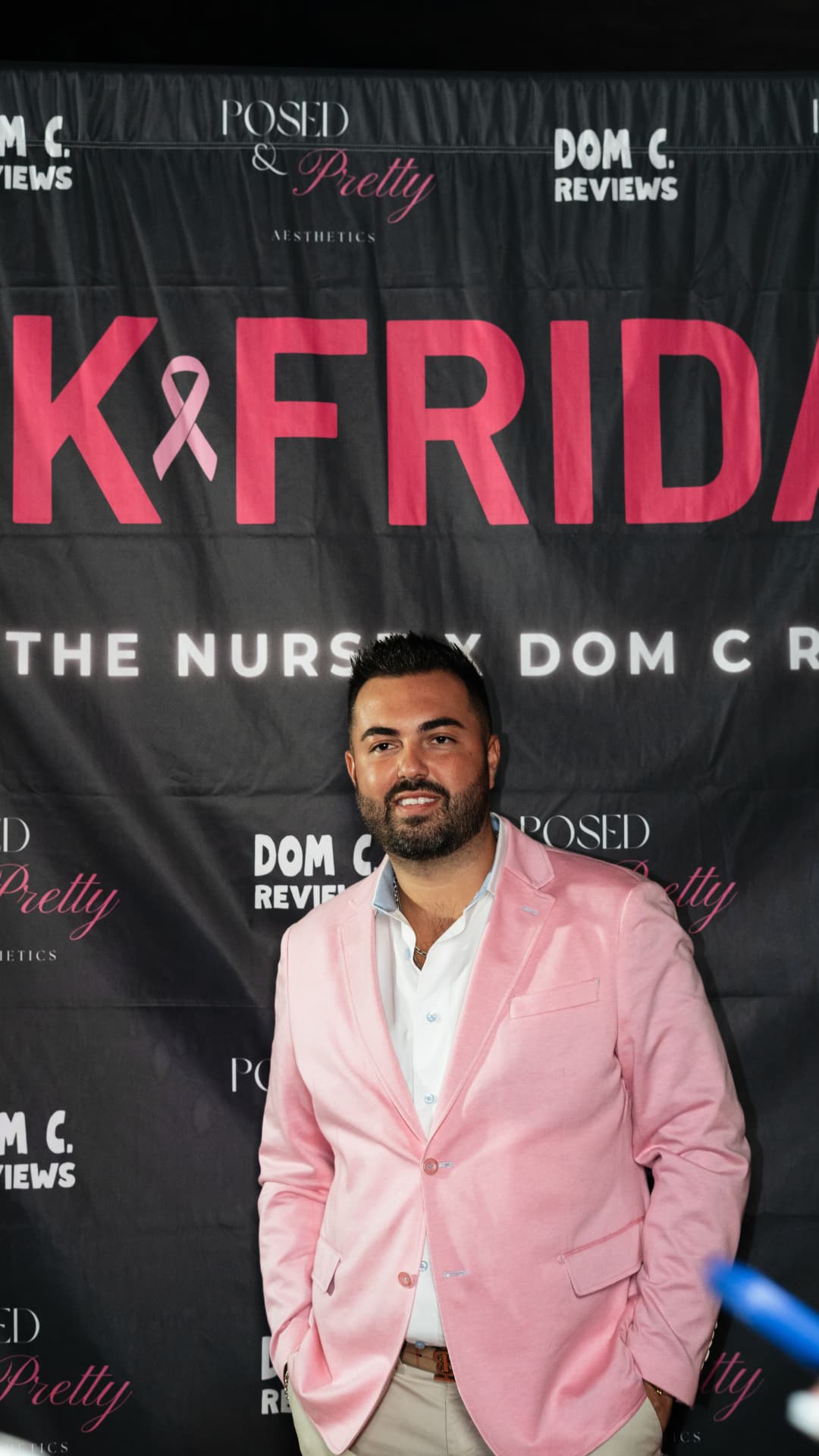 Dom C in a pink blazer in front of the Pink Friday backdrop